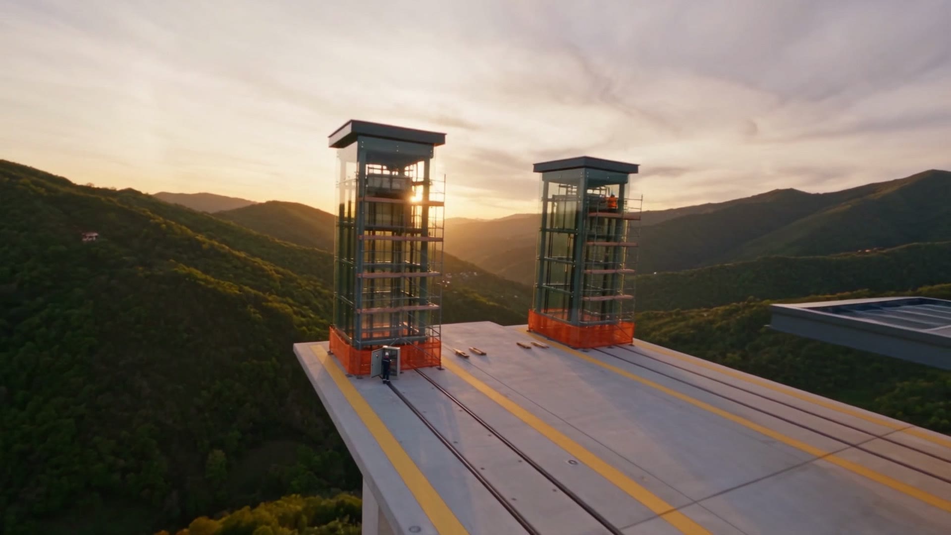 I due ascensori panoramici in vetro sul terrazzo, al tramonto