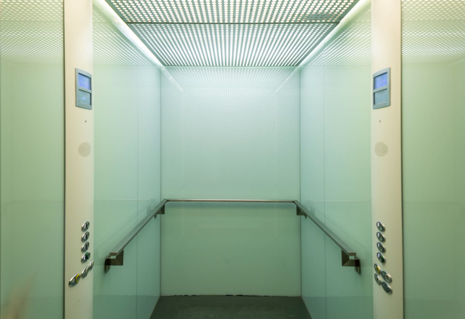 Una cabina ascensore vuota con rivestimento chiaro e luce morbida
