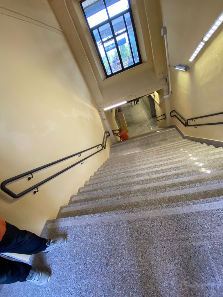 Uno scalone interno in pietra con corrimano metallico