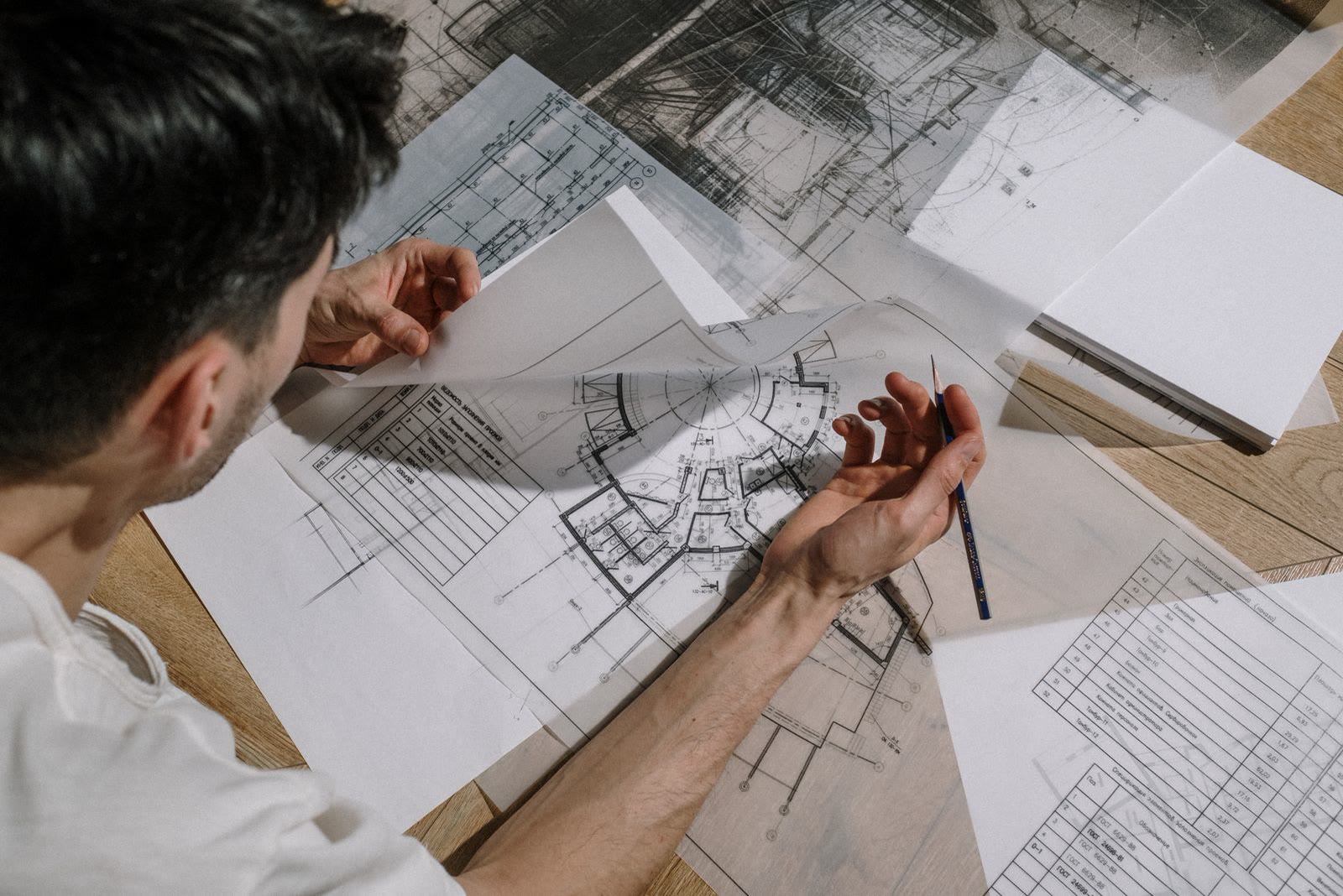 Un architetto disegna a mano sopra i disegni tecnici